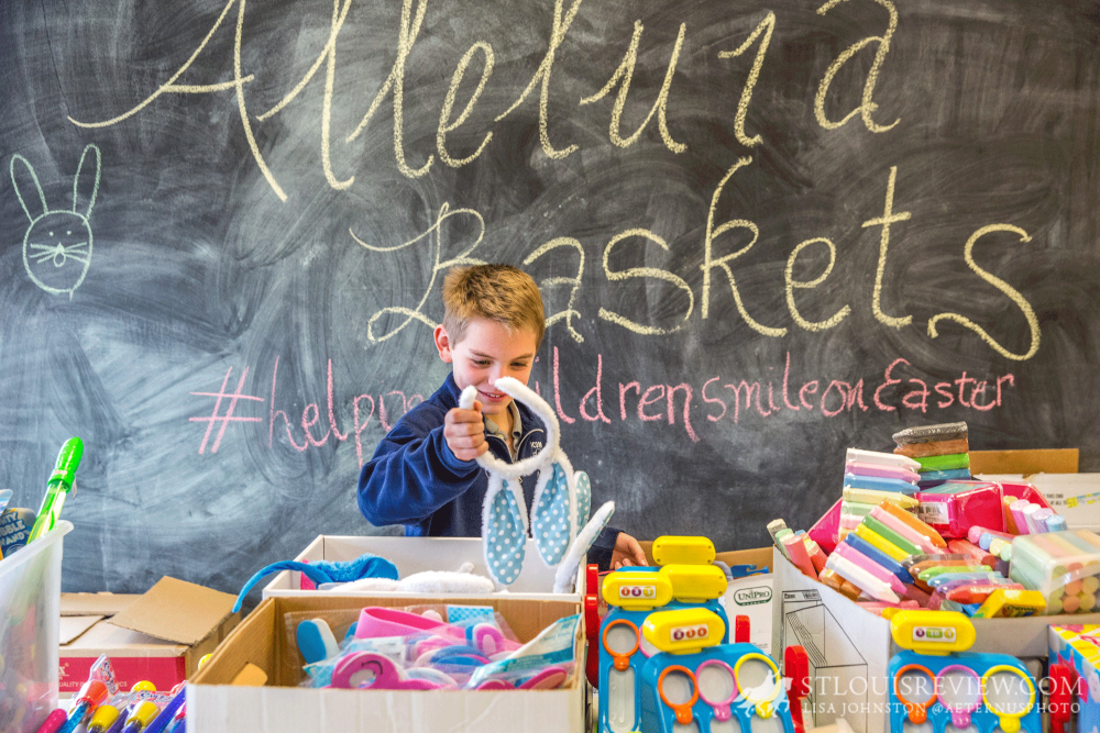 William Gnade, a second-grader at Immaculate Conception School in Old Monroe, looked for items to place into an Alleluia Basket. This year, 3,000 baskets will be given to children in need, with more than 600 volunteers helping pack the baskets.