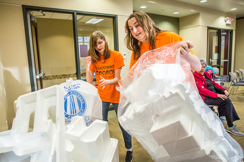 Christina Yepez, left, and Caroline Sluss stacked plastic foam, which they’ll convert to an adhesive they call EcoGLOo. The girls collected foam at a recycling
event at the Sunset Hills Community Center Jan. 11.