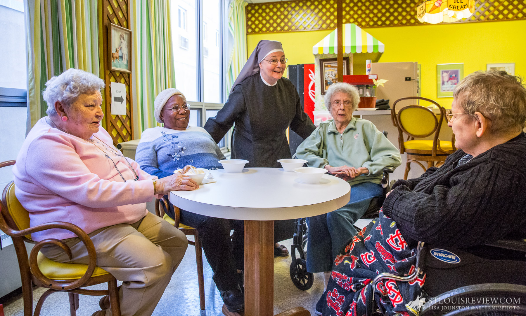 Sister Joseph Maureen Hobin, LSP, joked with residents (from left) Mary Hafner, Ester Allen, Mary Louise Doetsch and Maureen Giraffa, after they had snacks of ice
cream and popcorn. The Little Sisters of the Poor continue to assist the elderly poor but support is sought for their work, including with winter heating bills.