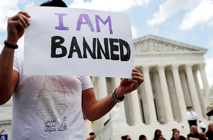 Mehrad Ansari, a university student from Iran, held a sign outside the U.S. Supreme Court building in Washington, D.C., June 26. After the Supreme Court upheld the travel ban on several predominantly Muslim countries including Iran, Ansari said he cannot go home to see his family now if he wants to return to the U.S.