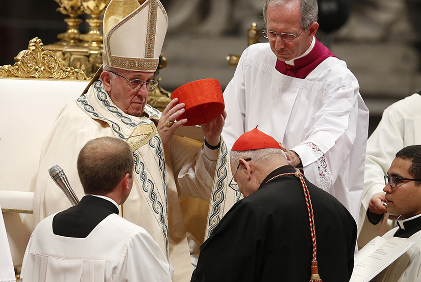 Pope Francis placed a red hat on new Cardinal Louis Raphael I Sako, the Chaldean Catholic patriarch, at a consistory at which the pope created 14 new cardinals June 28 in St. Peter’s Basilica.