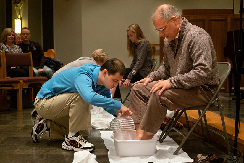 John Houston washed the feet of his father, Steve Houston, at Holy Thursday Mass at Sacred Heart Church in Valley Park. John has autism, and the family has helped the parish become a more welcoming place for children with disabilities.