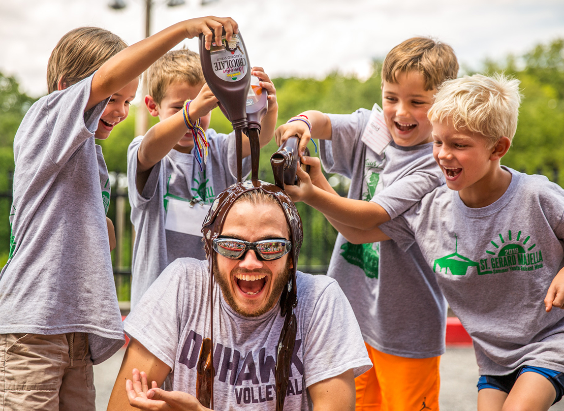 Sam Gerbic, a Totus Tuus misionary from Incarnate Word Parish, was transformed into a human sundae on July 27 as, from left, Giorgio Jansen, Jacob Wolf, Reid Ellis and Tommy Schneller poured chocolate sauce on him.