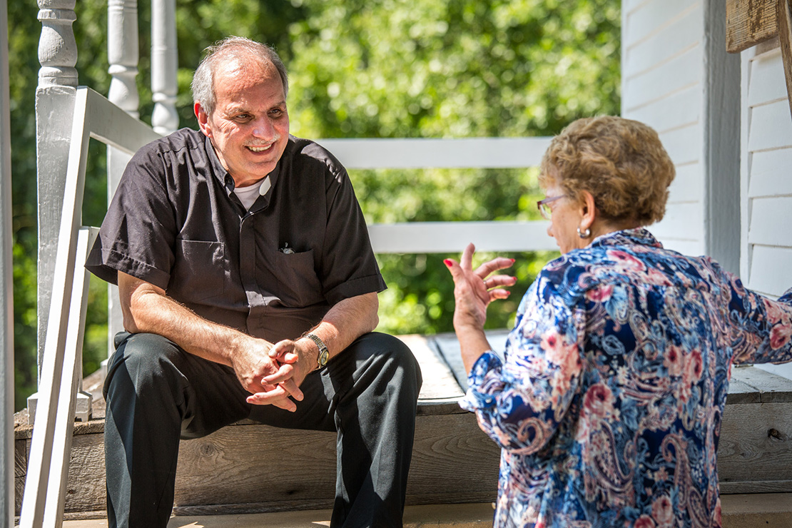 Father Rickey Valleroy talked with Veneita Carron on the steps of a one-room schoolhouse museum next to St. Lawrence Church in Lawrenceton. Father Valleroy recently became the pastor of St. Lawrence in Lawrenceton and St. Agnes in Bloomsdale after recovering from health issues.