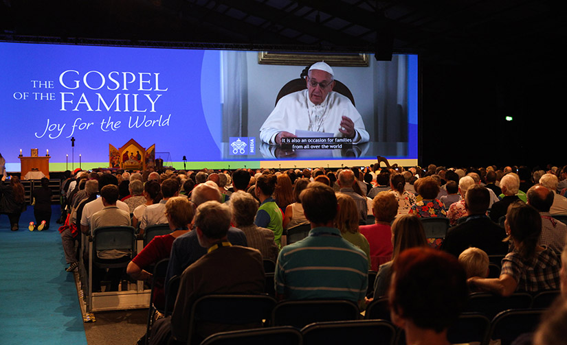 Attendees watched Pope Francis on a screen during the opening ceremony of the World Meeting of Families in Dublin Aug. 21. The pope will visit Ireland Aug. 25-26.