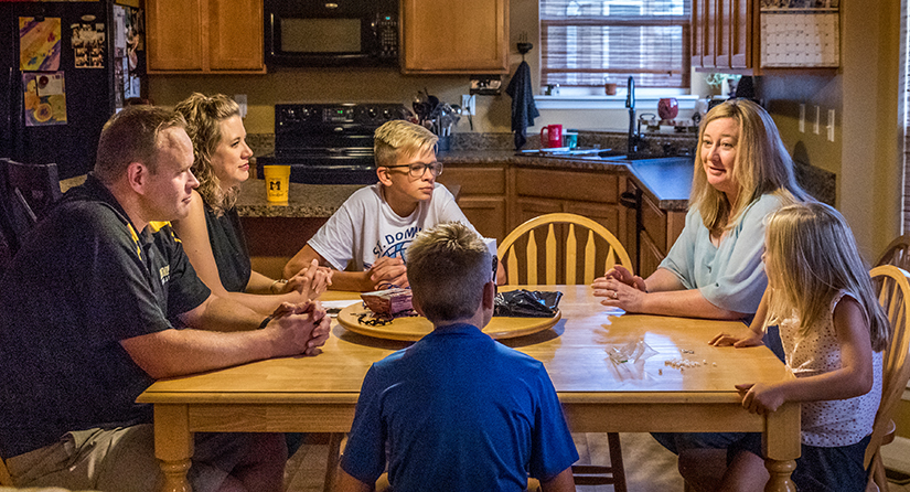 Melinda Kruper, right, of Assumption Parish in O'Fallon, visited with Jason and Misty Koenic and their children, Sam, Ethan and Maria, at their home on Aug. 1.