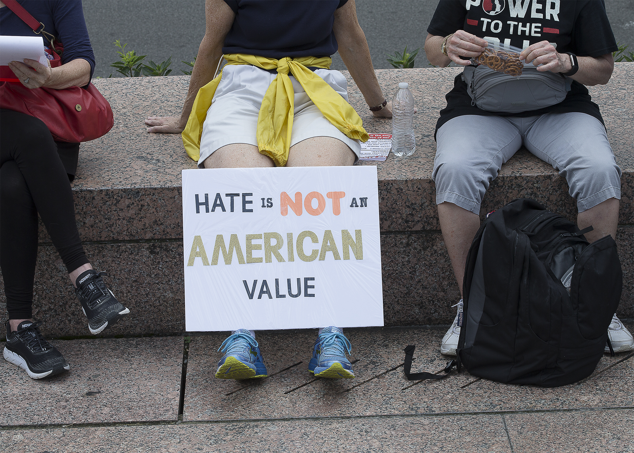 A person holds an anti-racism poster Aug. 12 in Washington. Msgr. Raymond G. East, pastor at St. Teresa of Avila Catholic Church in Washington, says racism is a worldwide phenomena and problem, and a peculiar institution in the United States. 