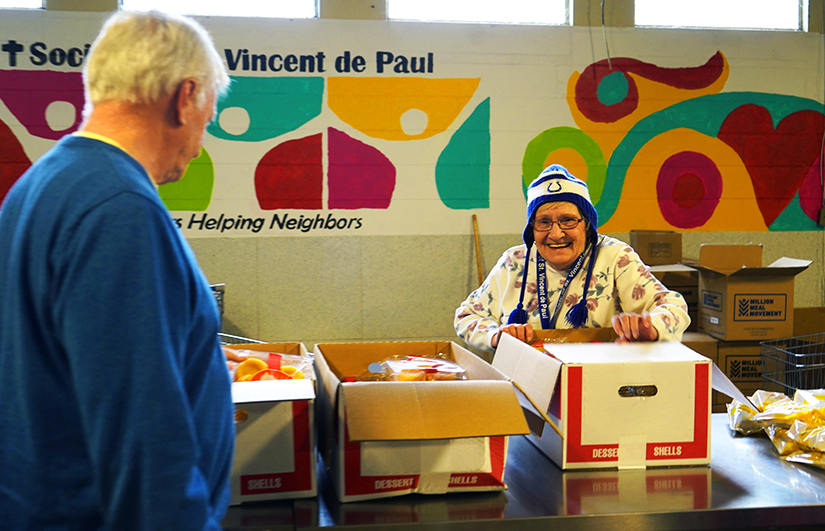 Volunteer Dee Poteet opened a new box of dessert shells to distribute to clients Nov. 15 at the Catholic-run Indianapolis food pantry operated by the Indianapolis Council of the Society of St. Vincent de Paul.