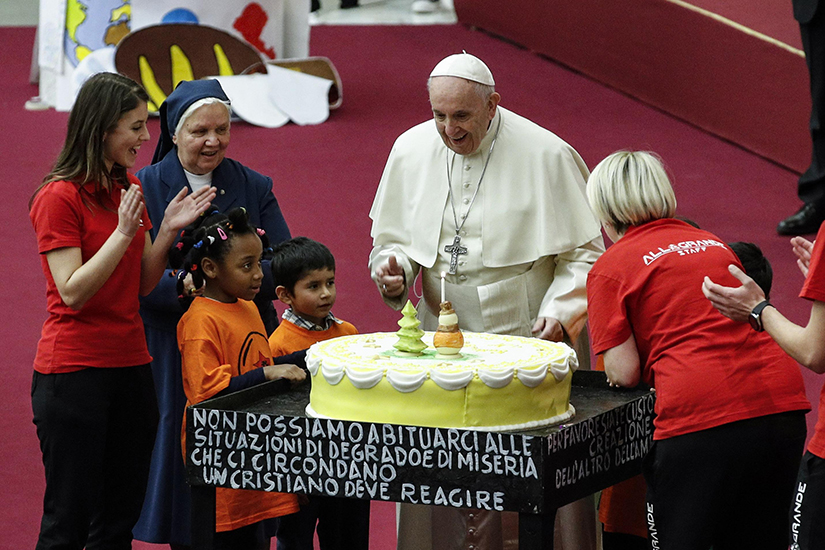 Pope Francis was presented with a cake on the eve of his 82nd birthday at an audience Dec. 16 with children and families from the Santa Marta Dispensary, a Vatican charity that offers special help to mothers and children in need.