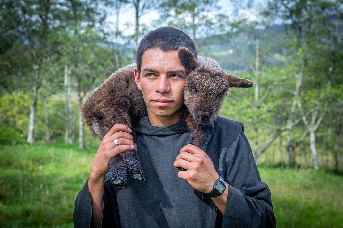 Brother Jeffers de Nuestra Señora de Guadalupe carried a sick lamb as he moved sheep to a different pasture at the monastery of Our Lady of Guadalupe in Arcabuco, Colombia.