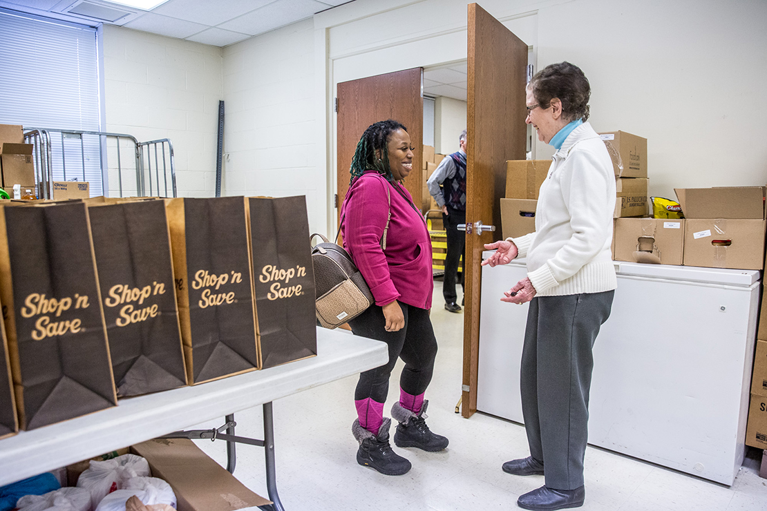 Shazell, left, a mother of four, visited the St. Vincent de Paul conference at Holy Name of Jesus Parish in Bellefontaine Neighbors on Feb. 2 to apply for utility assistance. She was helped by volunteer Annette Bligh, who invited her to come back next week and take advantage of their food pantry.