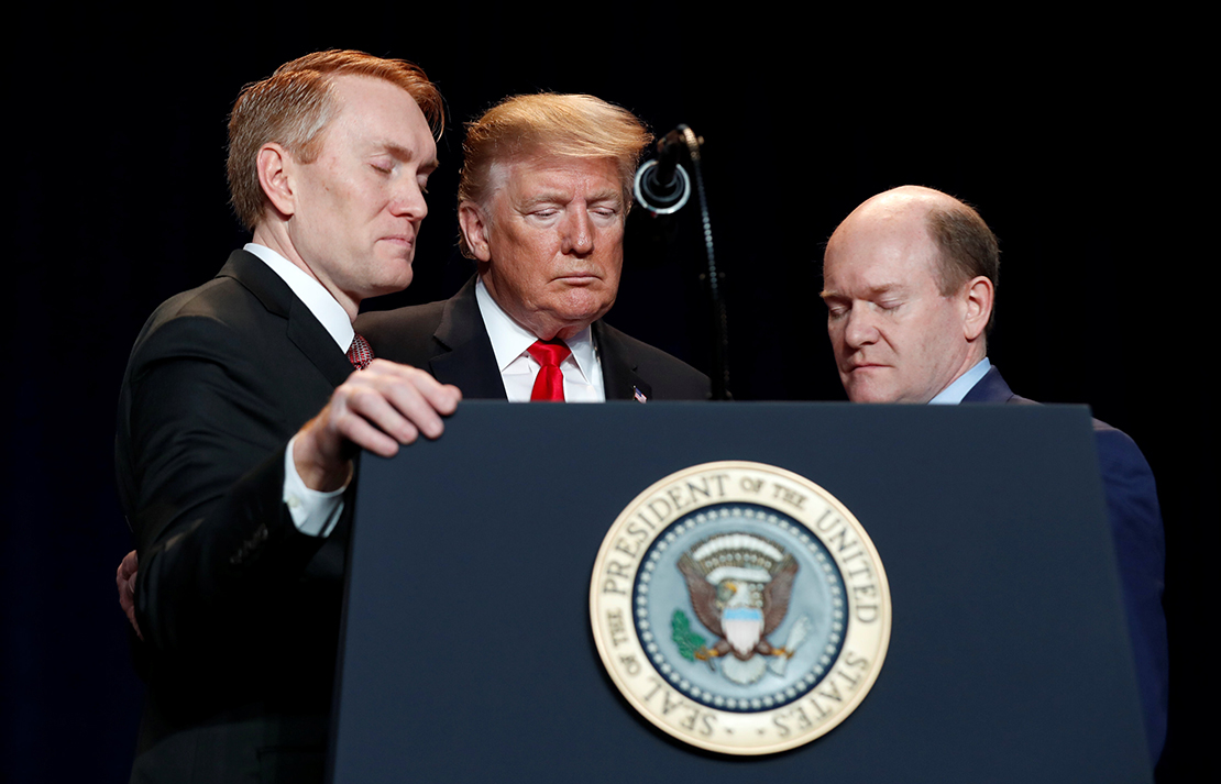 U.S. President Donald Trump prayed with Sens. James Lankford, R-Okla., and Chris Coons, D-Del., at the National Prayer Breakfast in Washington Feb. 7.