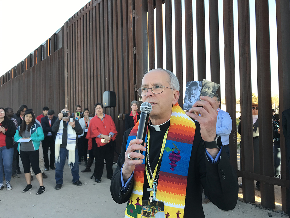 Bishop Mark J. Seitz of El Paso, Texas, held photos of two migrant children who died in U.S. custody; he spoke during the Feb. 26 Interfaith Service for Justice and Mercy at the Border near Sunland Park, N.M.