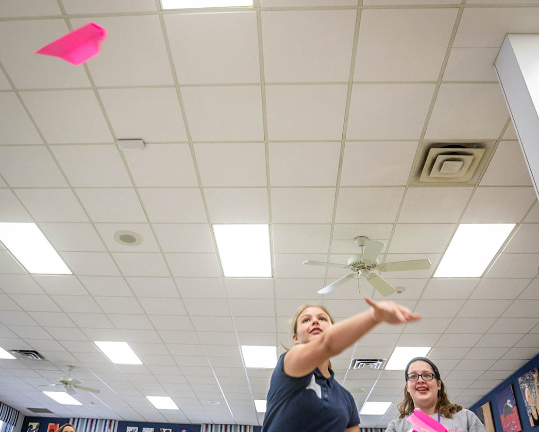 Belle Pastrana, a middle school student at St. Francis of Assisi School, threw a paper airplane as part of an exercise between students from St. Francis of Assisi and Rosati-Kain High School. The exercise is part of a partnership between the middle and high schools and focused on finding creative ways to show the extent of the problem of poverty.