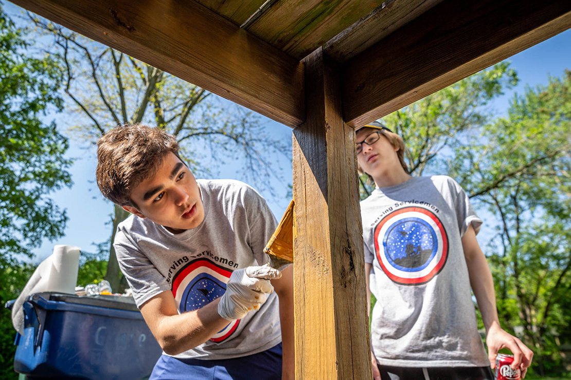 Jack Hood and Alex Flerlage stained a deck at the home of Dale and Carol Wiseman in St. Peters on May 14. The Christian Brothers College High School students are part of Serving Servicemen service organization that assists veterans.