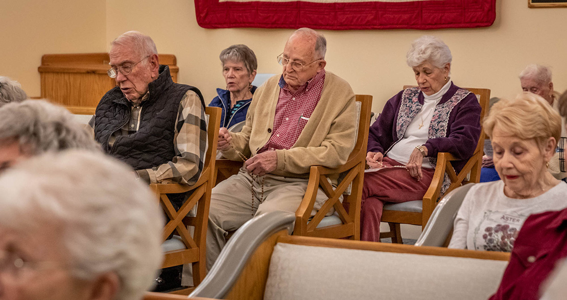 Charles Scherrer, center, 83, led the Rosary at Friendship Village in Sunset Hills April 1. Scherrer, who has been a parishioner of St. Elizabeth of Hungary since 1961, has been instrumental in the formation of a tight-knit Catholic community at the facility.