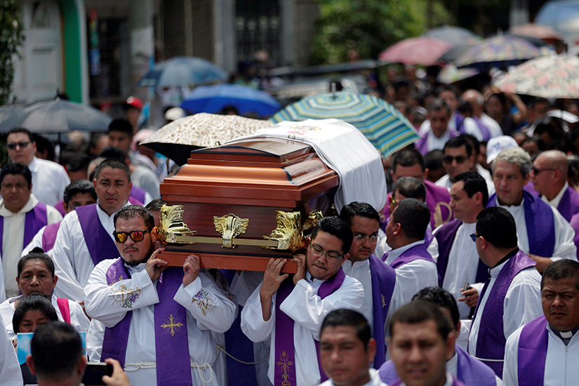 Priests carried the casket of Father Cecilio Perez Cruz during his funeral procession in Sonzacate, El Salvador, May 20, 2019. Parishioners found Father Perez dead in his residence in Juayua early May 18 with a note nearby that said he had not paid "rent," a euphemism for extortion money.