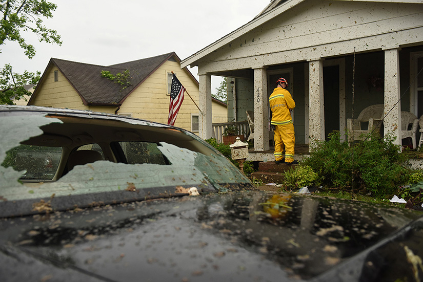 A firefighter checks houses May 23 following a tornado in Jefferson City, Mo. The May 22 tornado tore apart buildings in Missouri’s capital city as part of an overnight outbreak of severe weather across the state that left at least three people dead and dozens injured.