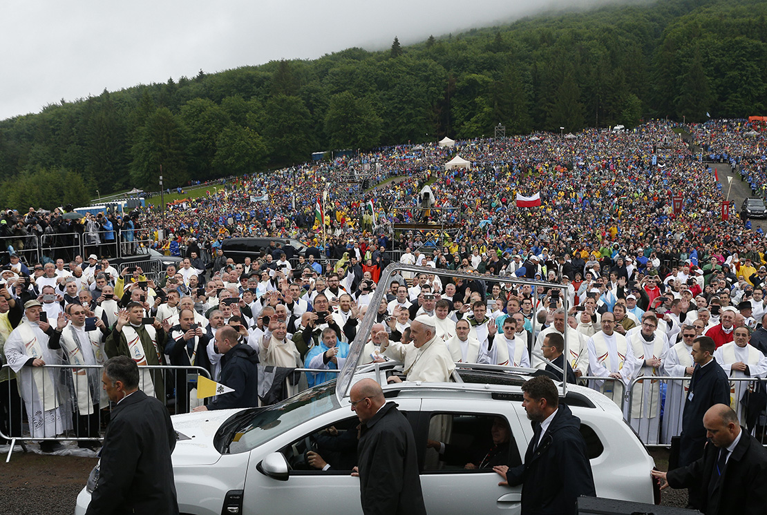 Pope Francis greeted the crowd before Mass at the Marian shrine of Sumuleu Ciuc in Miercurea Ciuc, Romania, June 1. Tens of thousands of people attended the Mass despite rainy weather.