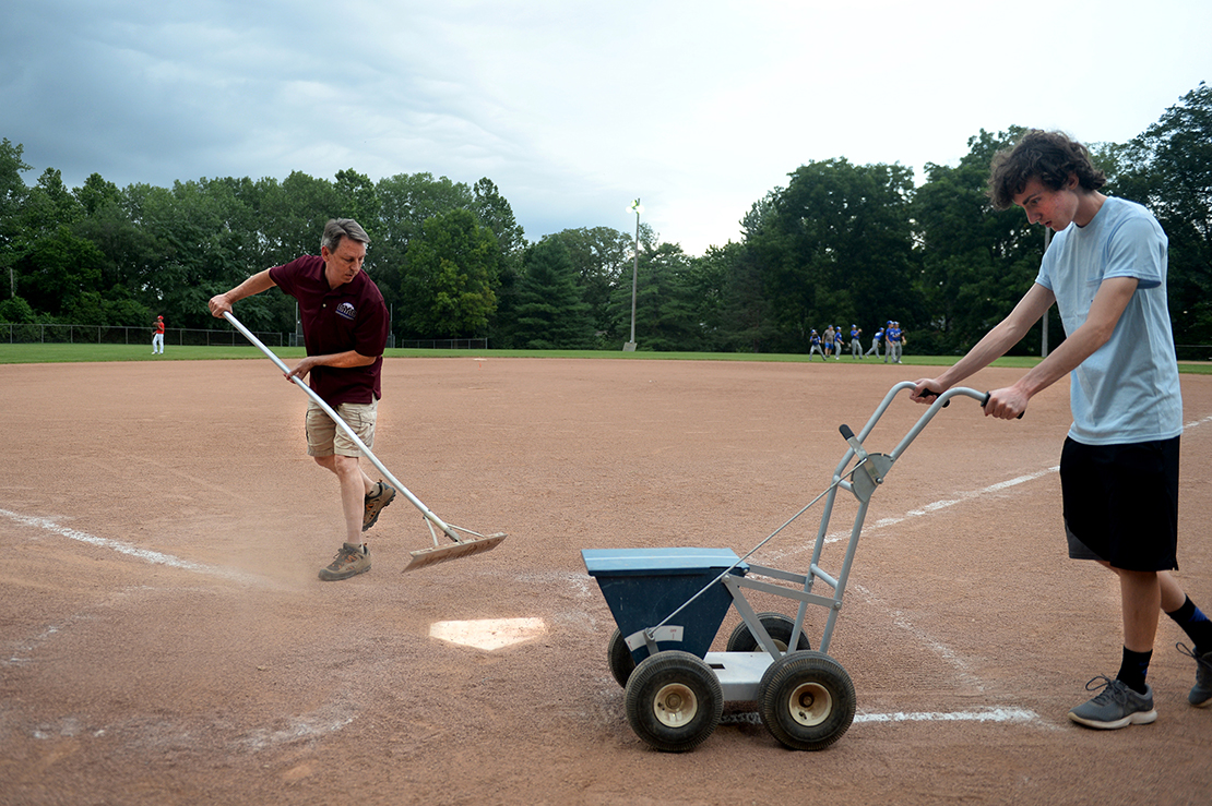 Tom Grassi, left, and his son, Brian, prepared the baseball diamond at the Kermit C. Albus Memorial Field at St. Elizabeth of Hungary Church in Crestwood. The Grassis are members of Mary Queen of Peace Parish’s “field maintenance ministry,” which maintains and uses the field for its Catholic Youth Council teams.