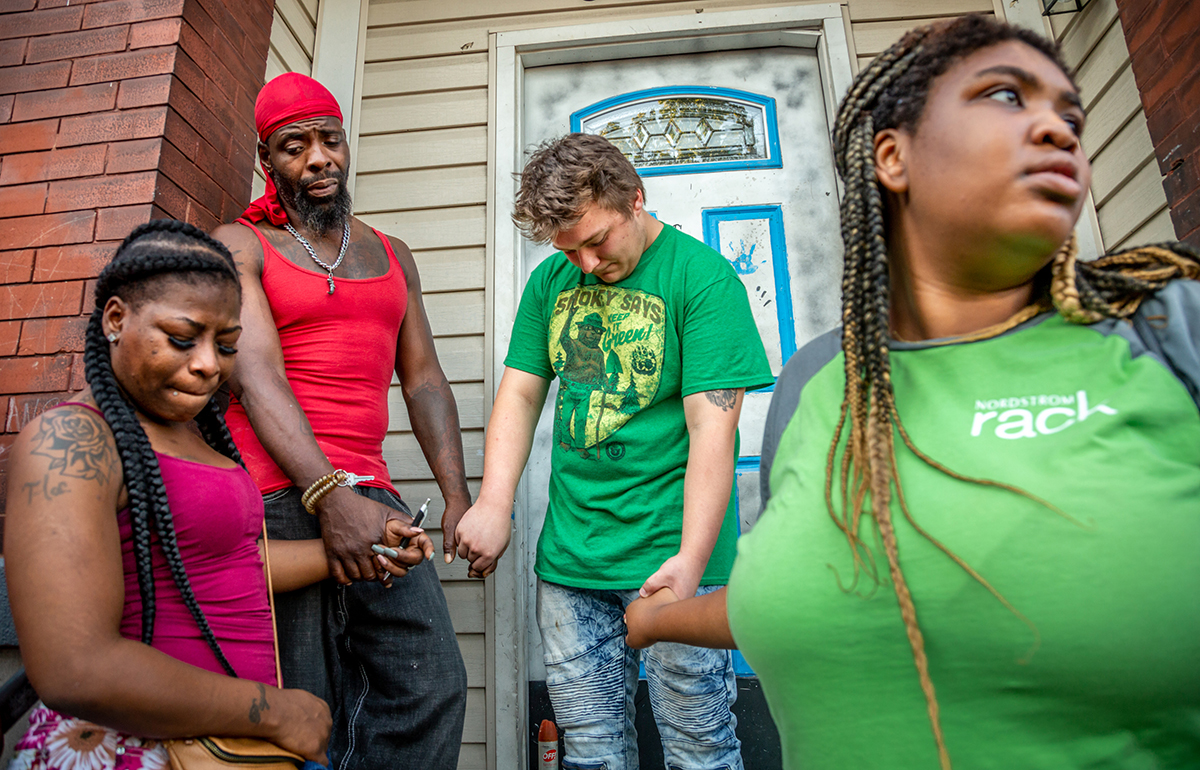 Patricia Henderson, Ifiok Usanga, Daniel Andrews and Dana Holden held hands during a prayer vigil Aug. 14 held for Usanga's 7-year-old son, Xavier Usanga, who was shot and killed outside his home Aug. 12.