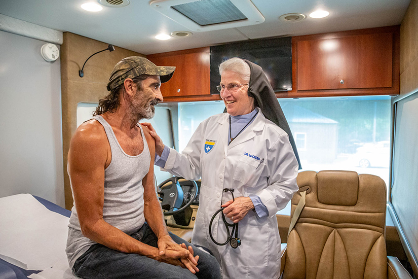 Physician Sister Marie Paul Lockerd, RSM, talked to Chip Hawkins during a check-up at the Rural Parish Clinic located at St. Joachim Parish Center in Old Mines. The clinic is up and running, providing health care services to the uninsured poor in Washington County.