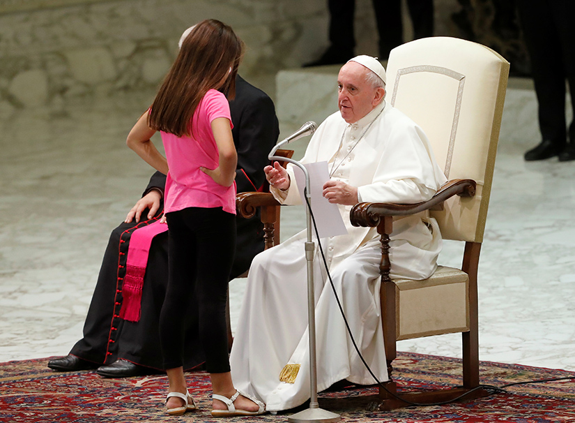 Clelia Manfellotti, a 10-year-old girl with autism from Naples, Italy, talked with Pope Francis during his general audience in Paul VI hall at the Vatican Aug. 21. As the girl moved around clapping and dancing on the stage, the pope told his security detail to “let her be. God speaks” through children.