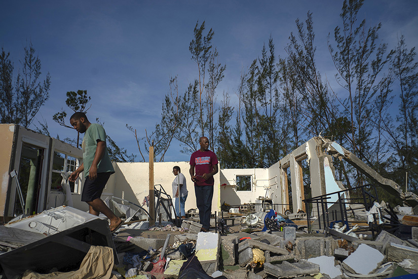 George Bolter, left, and his parents walk through the remains of his home destroyed by Hurricane Dorian in the Pine Bay neighborhood of Freeport, Bahamas, on Sept. 4. Rescuers trying to reach drenched and stunned victims in the Bahamas fanned out across a blasted landscape of smashed and flooded homes Sept. 4, while disaster relief organizations rushed to bring in food and medicine.