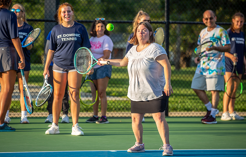 Megan Layton returned the ball across the net as the St. Dominic High School tennis team taught the game of tennis Sept. 4 to residents of St. Louis Life, a community-based, residential program for adults with developmental disabilities.