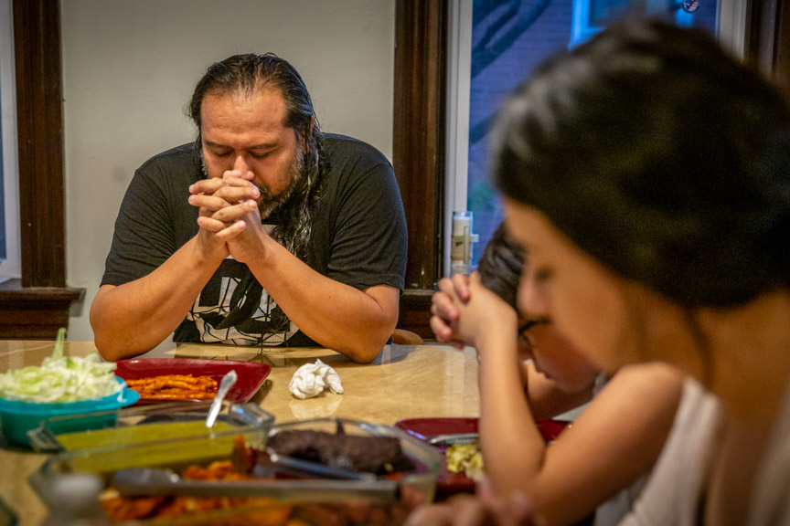 Daniel Mendoza led his family in prayer before they ate enchiladas at dinner celebrating 18-year-old Ashley's birthday at the Estrada-Mendoza home in St. Louis, MO on Thursday, Sep. 12, 2019.  