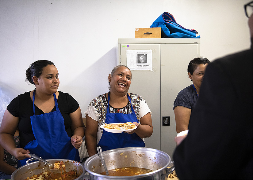 Migrants shared a light moment while serving food to a delegation of U.S. bishops and Church leaders Sept. 24 at Corpus Christi Church in Ciudad Juarez, Mexico. The Sept. 23-27 pastoral visit, sponsored by various offices of the U.S. Conference of Catholic Bishops and other national organizations, aimed to highlight the Church’s ministry to migrants, the border conditions and immigration laws affecting them, and their material and spiritual needs.