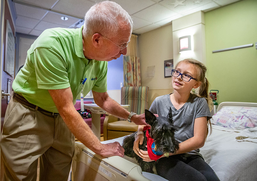 Ten-year-old Audrey Hoffmann met Deacon Lonnie Weishaar and his therapy dog, Sadie, a Scottish Terrier, at Mercy Hospital St. Louis in Creve Coeur on Oct. 29. Deacon Weishaar estimates he has visited more than 400 patients with Sadie.