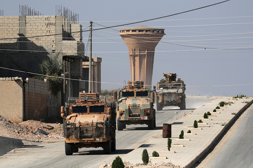 A convoy of Turkish military vehicles moved through the town of Tal Abyad, Syria, Oct. 23. People in northeastern Syria say despite Turkish President Recep Tayyip Erdogan’s reassurances, the Turkish military and its allied Syrian armed groups are persecuting religious minorities.