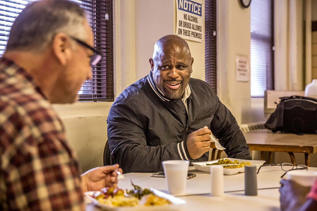 Father Dempsey’s Charities director Sam Irons ate dinner with
resident Charles Phillips. “I try to treat people with compassion,” he said, a trait he learned by watching Archbishop Robert J. Carlson during their time together.