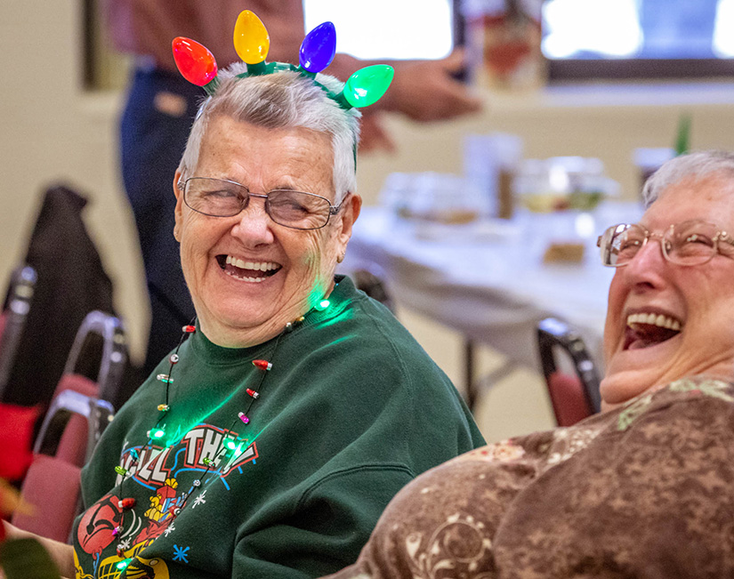 Pat Walkenhorst, left, laughed with her friend Connie Zurawski as they ate lunch with more than 200 seniors at St. Robert Bellarmine Parish in St. Charles Dec. 4. The parish hosts the senior luncheon every month except for January and July.