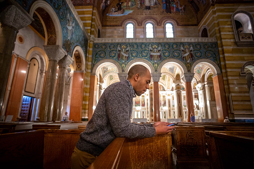 Louis Jones, an intern with the Catholic Campaign for Human Development, prayed before Mass at Cathedral Basilica of Saint Louis Dec. 10. Jones was drawn back to his Catholic faith after reading more about Catholic social teaching.