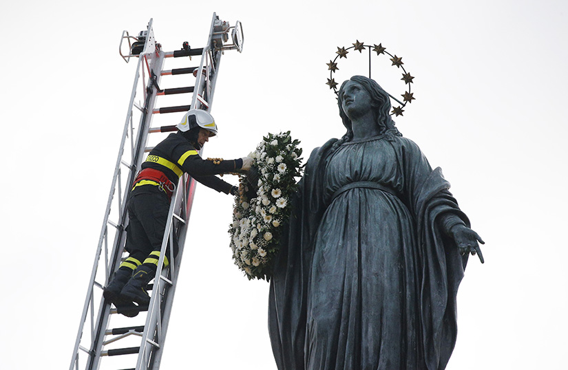 A firefighter placed a wreath on a Marian statue overlooking the Spanish Steps in Rome Dec. 8, the feast of the Immaculate Conception. Later in the day, the pope recited a prayer he wrote for the occasion.