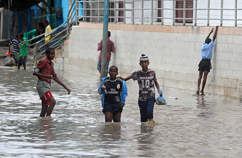 Young Somalis walked through floodwaters after heavy rains in Mogadishu Nov. 26. Caritas, the relief arm of the Catholic Church, has delivered food aid to Muslims in Somalia, who are currently facing floods and living in a fragile peace environment due a prolonged Islamist insurgency.