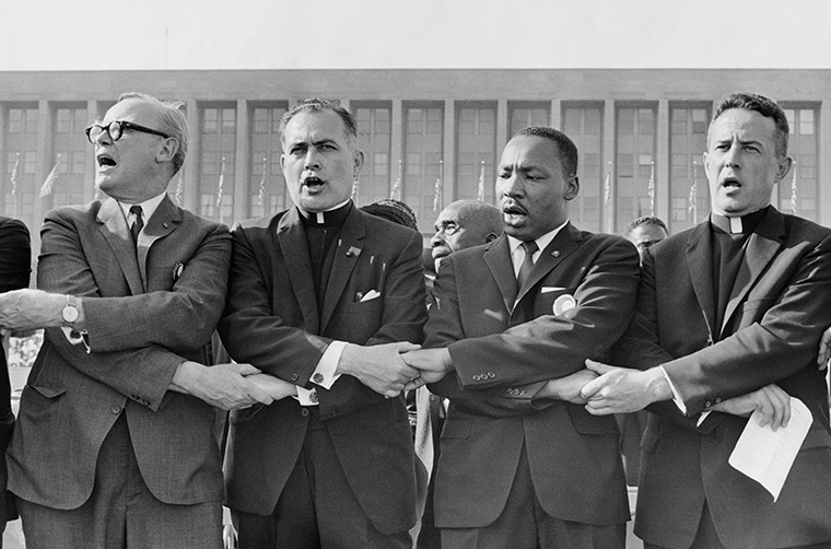 Holy Cross Father Theodore Hesburgh, then president of the University of Notre Dame, second from left, joined hands with the Rev. Martin Luther King Jr., the Rev. Edgar Chandler and Msgr. Robert J. Hagarty of Chicago, far right, in this 1964 file photo. Fifty years after Rev. King’s assassination, advocates say there is still work to do in dismantling racism.