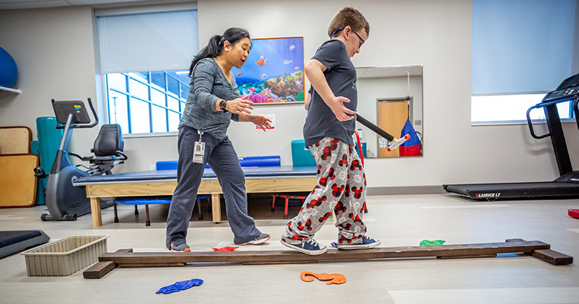 Eight-year-old Isaac Vincent walked on a balance beam with physical therapist Bing Sabino at SSM Health Cardinal Glennon Pediatrics Specialty Services in south St. Louis County. The facility is one way that Cardinal Glennon is reaching out beyond its hospital setting.