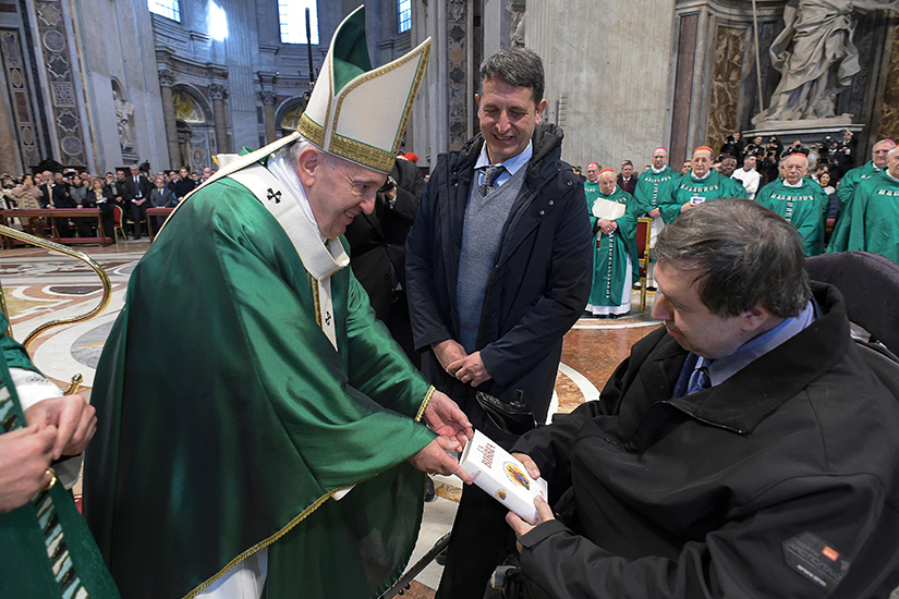 Pope Francis gave a Bible to a man in a wheelchair at the end of Mass Jan. 26 in St. Peter’s Basilica. The Mass marked the first Sunday of the Word of God, a new annual celebration encouraging Catholics to know and read the Bible. In the homily, the pope said that God’s saving word doesn’t seek pristine and safe places to reside, but instead goes in search of the dark corners of people’s lives that it can brighten.
