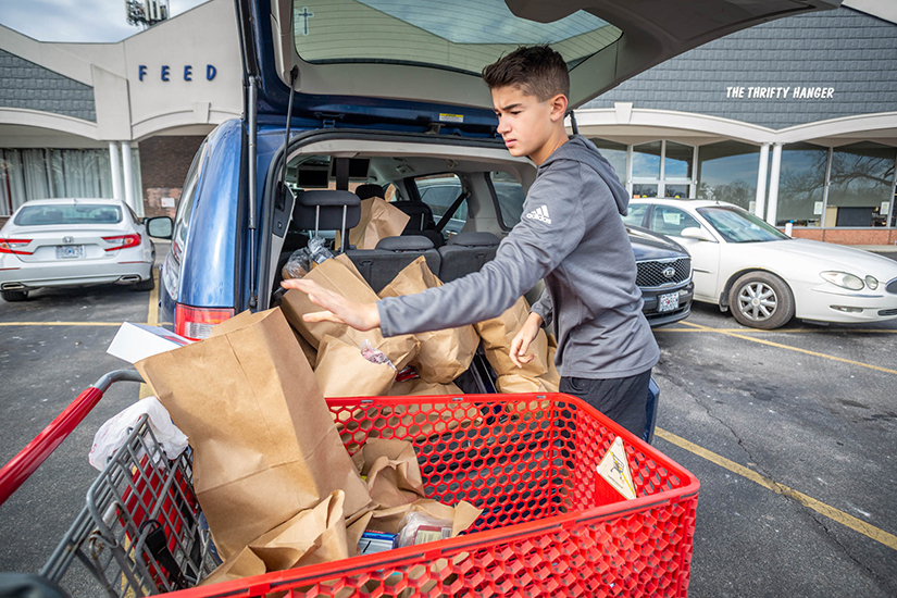 Andrew Ecker, a freshman at Chaminade College Preparatory High School, loaded a van filled with food for a family of six at Feed My People in Lemay Feb. 3. Ecker serves at the food pantry with his grandfather, Deacon Richard Schellhase of Queen of All Saints Parish.