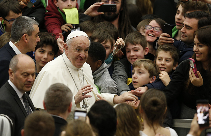 Pope Francis greeted the crowd as he arrived for his general audience in Paul VI Hall at the Vatican Feb. 5.