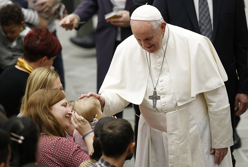 Pope Francis greeted a child as he led his general audience in Paul VI hall at the Vatican Feb. 12.
