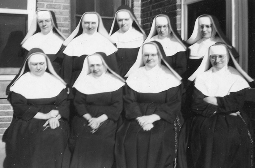 The Sisters of Charity of Zams gathered outside Kenrick Seminary. Shown, from left, are Sisters Dominata, Goberta, Frances, Bernarda, Villanova and, in the bottom row, Sisters Killiana, Helen, Theophilia and Adelharda. During the years leading up to the U.S. entrance into World War II and tightening immigration limits, the women religious from the community based in Austria ran into roadblocks when trying to work in their ministries in the United States, including at Kenrick Seminary in Shrewsbury.