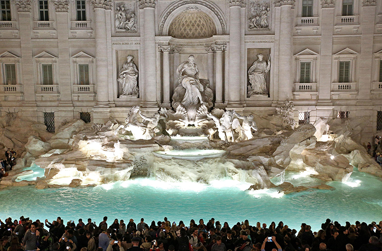 People gathered in front of the landmark Trevi Fountain after its 2015 restoration in Rome. While millions of tourists throw a coin over their shoulder into the fountain hoping to return to Rome one day, the money scooped out of the fountain each week offers more concrete hope to the city’s poor.