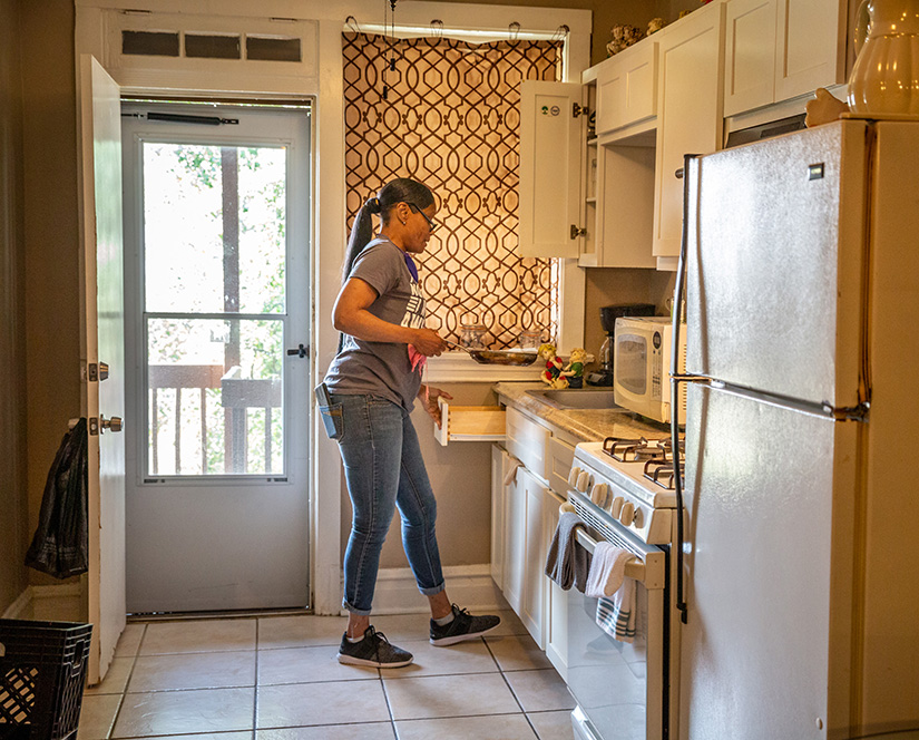 Sultana Davis has been housed in a new apartment by St. Patrick Center and receives other assistance from the agency. She washed dishes at her apartment in St. Louis March 30.