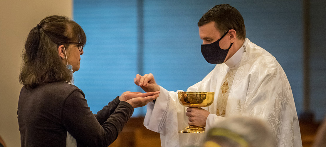 Father Anthony Yates distributed the Eucharist to during one of the first celebrated public Mass since the COVID-19 shut down at St. Francis of Assisi Parish church on Monday, May 18.