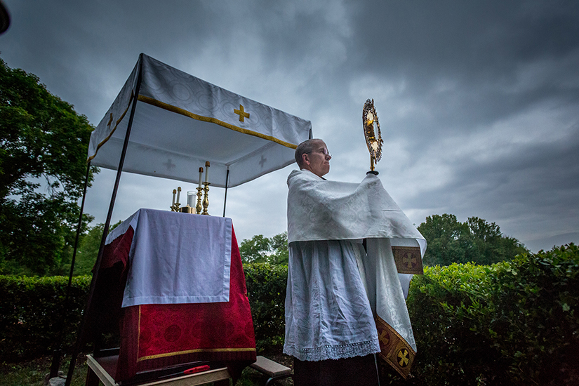 Father Aidan McDermott, OSB, offered Benediction during Eucharistic adoration at St. Louis Abbey. “It’s bringing Christ to the streets,” Father McDermott said, noting that he views it as a part of the new evangelization in reaching out to people.