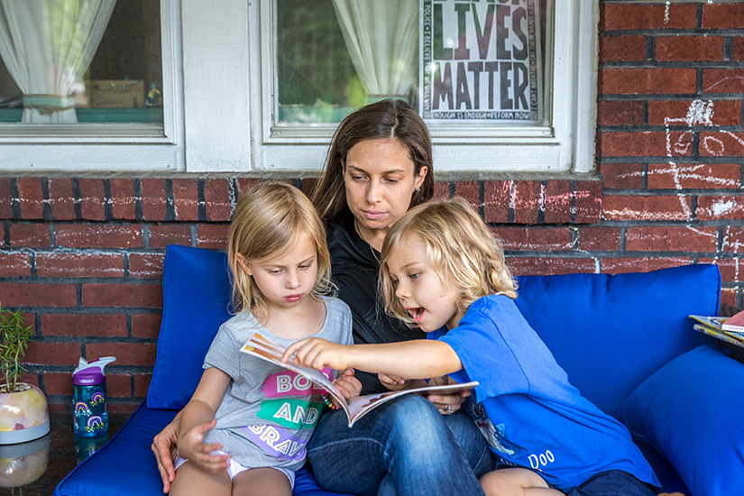 Teresa Steinkamp read “The Color of Us” by Karen Katz to her children Madeline and Keller on their porch on June 12. Steinkamp, a parishioner at St. Cronan Parish in St. Louis, is a volunteer faciliator with We Stories’ Family Learning Program.